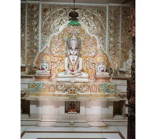 Sacred Tirthankara idol surrounded by celestial figures in a Jain temple